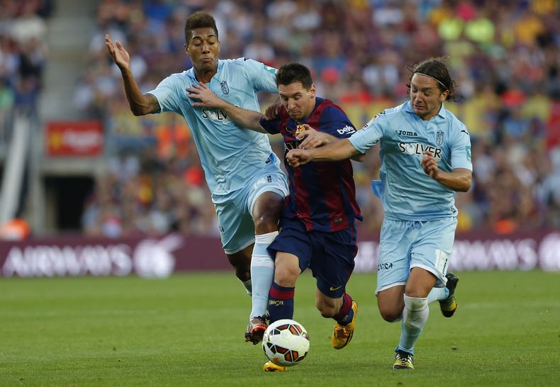 El jugador de la selecci&oacute;n de Argentina y del Barcelona, Lionel Messi, centro, disputa un bal&oacute;n en un partido contra el Granada el s&aacute;bado, 27 de septiembre de 2014, en Barcelona. (AP Photo/Emilio Morenatti)