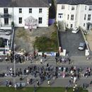 Fans reunidos fuera de la antigua casa de Sinéad OConnor previo al funeral de la cantante en Bray, en el condado de Wicklow, Irlanda, el martes 8 de agosto de 2023. (Niall Carson/PA vía AP)