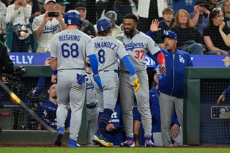 El boricua Kiké Hernández (8) festeja con el dominicano Teoscar Hernández, su compañero en los Dodgers de Los Ángeles, durante el juego ante los Marineros de Seattle, el viernes 26 de septiembre de 2025 (AP Foto/Ryan Sun)