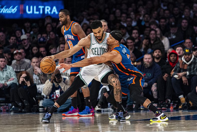 El escolta de los Knicks de Nueva York, Josh Hart (3), defiende contra el alero de los Celtics de Boston, Jayson Tatum, al frente a la izquierda, durante la segunda mitad del partido de baloncesto de la NBA en Nueva York, el sábado 24 de febrero de 2024. (AP Foto/Peter K. Afriyie)