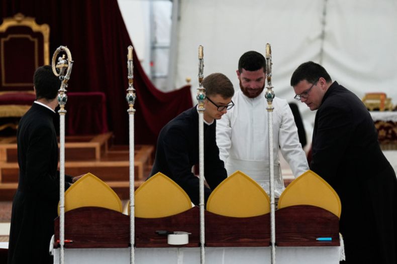 Sacerdotes preparan mitras y bastones antes del inicio de una ceremonia de consagración de cuatro nuevos obispos en una carpa ante el seminario de la Fraternidad San Pío X en Econe, Suiza, el miércoles 1 de julio de 2026. (AP Foto/Baz Ratner)