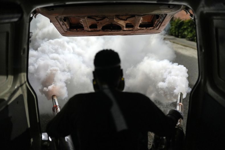 Un trabajador fumiga un vecindario contra el mosquito que propaga el dengue, en Caracas, Venezuela, el 12 de diciembre de 2023. (AP Foto/Matías Delacroix)