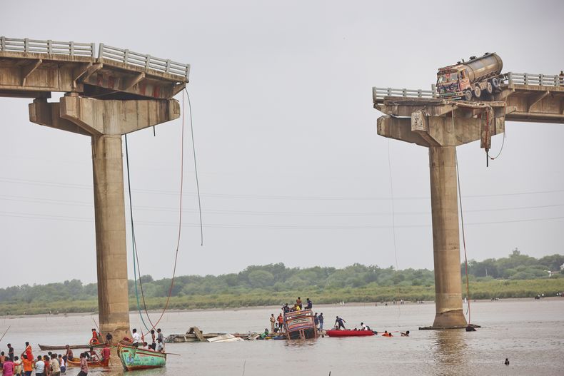 Rescatistas y vecinos buscando sobrevivientes después de que varios vehículos cayeran al río tras el colapso de un tramo de un puente en Mujpur, cerca de Vadodara, en el estado indio de Gujarat, el miércoles 9 de julio de 2025. (AP Foto)