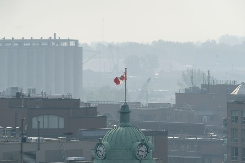 Una bandera canadiense en medio de un cielo nublado en Toronto el viernes 6 de junio de 2025 a causa del humo de unos incendios forestales que arden en dos provincias de Canada. (Giordano Ciampini /The Canadian Press vía AP)