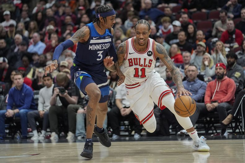 El alero de los Timberwolves de Minnesota Jaden McDaniels (izquierda), marca al alero de los Bulls de Chicago, durante la prórroga de un partido de baloncesto de la NBA, el martes 6 de febrero de 2024, en Chicago. (AP Foto/Erin Hooley)