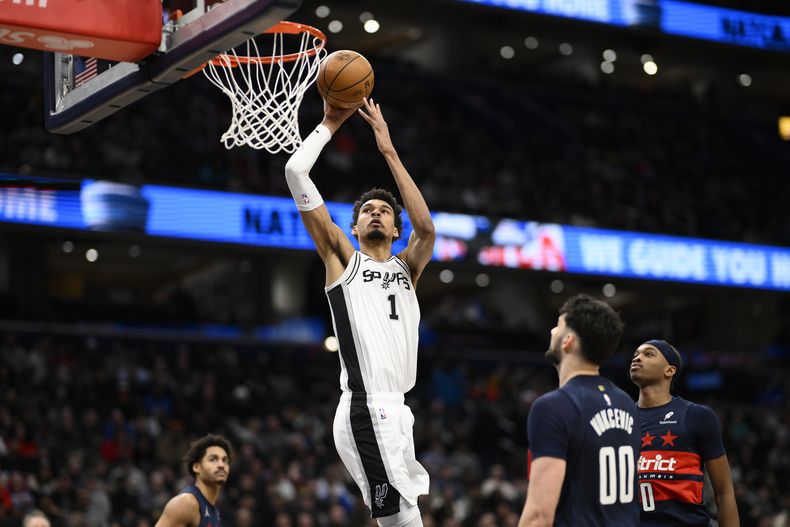 El pívot de los Spurs de San Antonio Victor Wembanyama salta para anotar frente a Tristan Vukcevic y Bilal Coulibaly de los Wizards de Washington el lunes 10 de febrero del 2025. (AP Foto/Nick Wass)