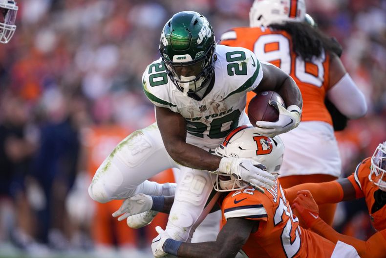 El corredor de los Jets de Nueva York Breece Hall tacleado por el safety de los Broncos de Denver Kareem Jackson en el encuentro del domingo 8 de octubre del 2023. (AP Foto/David Zalubowski)