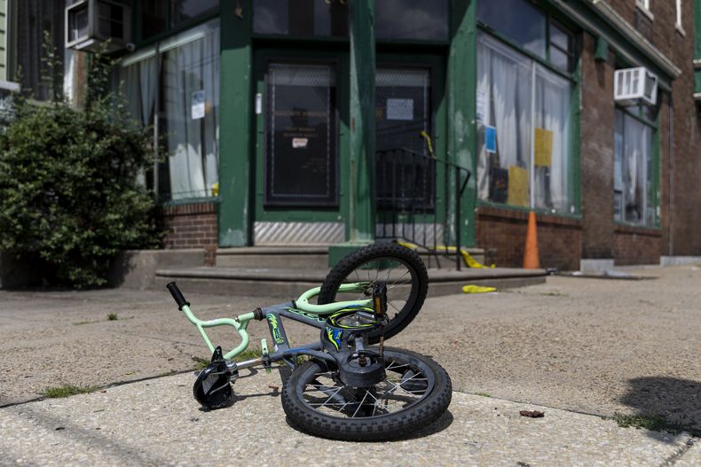 La bicicleta de un niño yace en el lugar donde ocurrió un tiroteo, el martes 4 de julio de 2023, en Filadelfia. (Tyger Williams/The Philadelphia Inquirer vía AP)