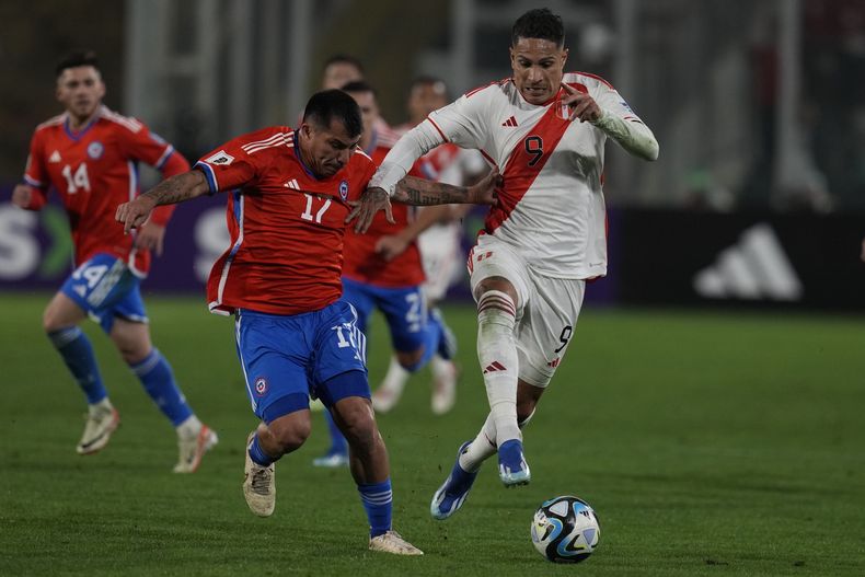 José Guerrero de Perú pelea por el balón con Gary Medel de Chile en el encuentro de la eliminatoria sudamericana a la Copa Mundial 2026 el jueves 12 de octubre del 2023. (AP Foto/Esteban Felix)