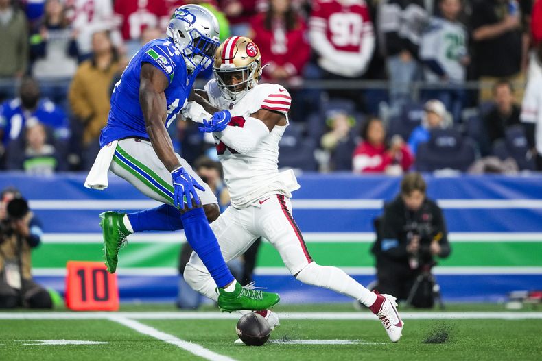 George Odum, derecha, safety de los 49ers de San Francisco, forza un pase incompleto del wide receiver DK Metcalf (14), de los Seahawks de Seattle, durante la primera mitad del partido de la NFL, el jueves 10 de octubre de 2024, en Seattle. (AP Foto/Lindsey Wasson)