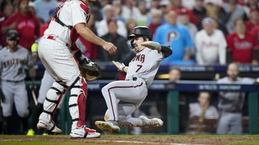 Corbin Carroll, de los Diamondbacks de Arizona, anota frente a J.T. Realmuto, cátcher de los Filis de Filadelfia, en el séptimo juego de la Serie de Campeonato de la Liga Americana, el martes 24 de octubre de 2023 (AP Foto/Matt Slocum)