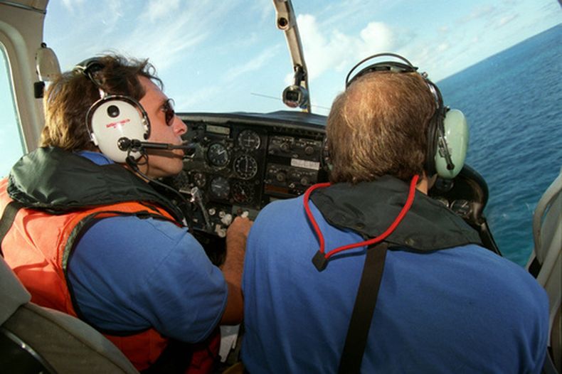 ARCHIVO - El piloto Ivan Domaniewicz (izquierda) y el copiloto Carlos Costa, ambos de Hermanos al Rescate, sobrevuelan el estrecho de Florida el 31 de agosto de 1993, en busca de personas que pudieran haber estado en balsas improvisadas huyendo de Cuba. (AP Foto/Lynne Sladky, archivo)