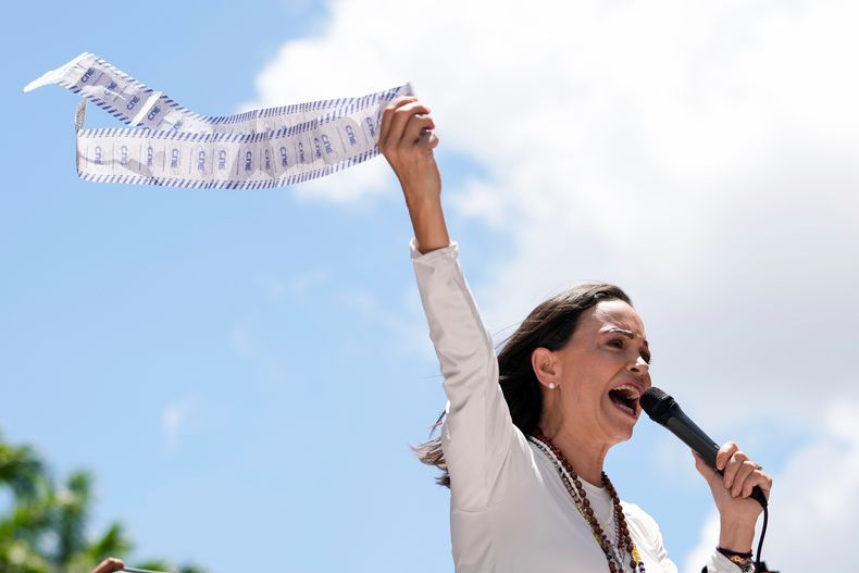 ARCHIVO - La líder opositora María Corina Machado muestra una hoja de conteo de votos durante una protesta contra la reelección de Nicolás Maduro como presidente de Venezuela, un después después de unos polémicos comicios en los que, según afirma, la oposición ganó por una amplia mayoría, el 28 de agosto de 2024, en Caracas, Venezuela. (AP Foto/Ariana Cubillos, archivo)