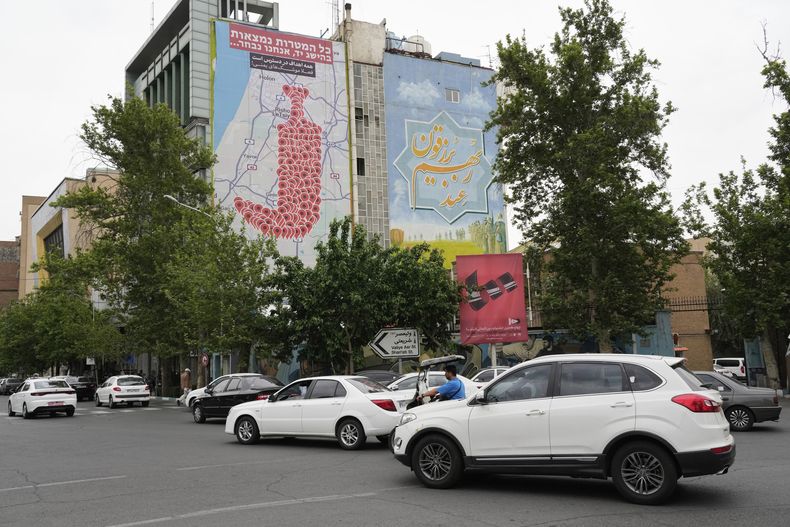 Vehículos pasan frente a un cartel anti-Israel que muestra varios lugares de Israel en forma de una daga yemení con las frases Todos los objetivos están al alcance, ¡misiles yemeníes ahora! en farsi y Todos los objetivos están al alcance, decidiremos, en hebreo, en la Plaza Palestina en el centro de Teherán, Irán, el lunes 5 de mayo de 2025. (AP Foto/Vahid Salemi)