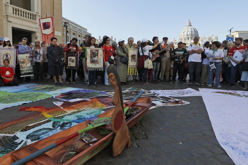 ARCHIVO - Una escultura de madera que representa a una mujer embarazada se ve al frente mientras miembros de pueblos indígenas amazónicos se preparan para una procesión del Via Crucis desde el castillo de St. Angelo al Vaticano, el 19 de octubre de 2019. (AP Foto/Andrew Medichini, Archivo)