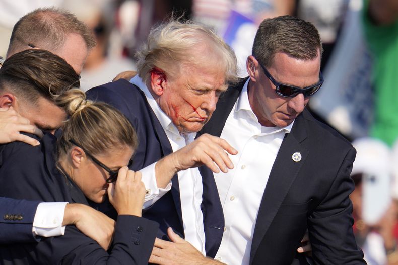 El expresidente y virtual candidato presidencial republicano Donald Trump recibe ayuda para bajar del estrado en un mitin de campaña en Butler, Pensilvania, el sábado 13 de julio de 2024. (AP Foto/Gene J. Puskar)