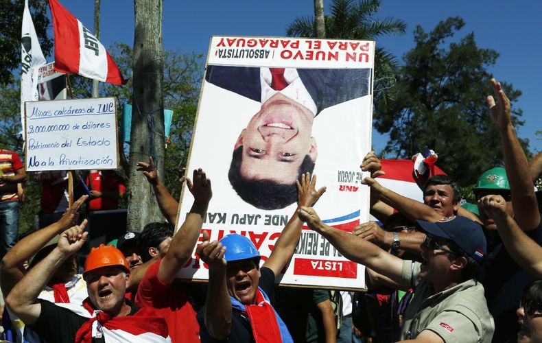Manifestantes protestan contra el presidente de Paraguay Horacio Cartes por una ley apoyada por el gobierno para privatizar varios servicios p&uacute;blicos en Asunci&oacute;n, el lunes 28 de octubre de 2013. (Foto AP/Jorge Saenz)