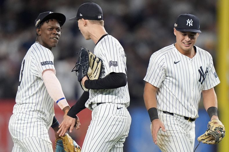 El tercera base de los Yankees de Nueva York, Jazz Chisholm Jr., a la izquierda, el lanzador Luke Weaver, al centro, y el campocorto Anthony Volpe celebran después de derrotar a los Reales de Kansas City en el Juego 1 de la serie divisional de la Liga Americana, el sábado 5 de octubre de 2024, en Nueva York. (AP Foto/Frank Franklin II)