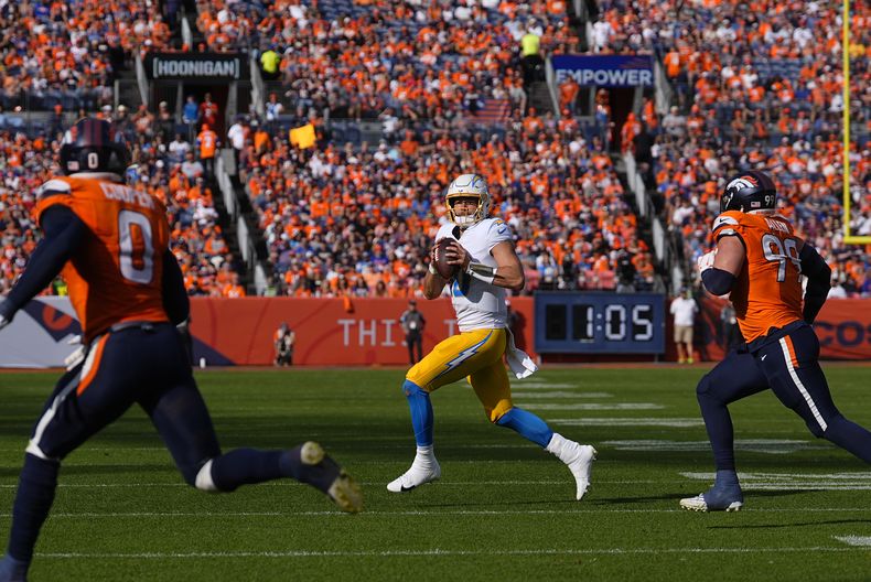 Justin Herbert (10), quarterback de los Chargers de Los Ángeles, busca lanzar un pase durante la primera mitad del juego de la NFL en contra de los Broncos de Denver, el domingo 13 de octubre de 2024, en Denver. (AP Foto/David Zalubowski)