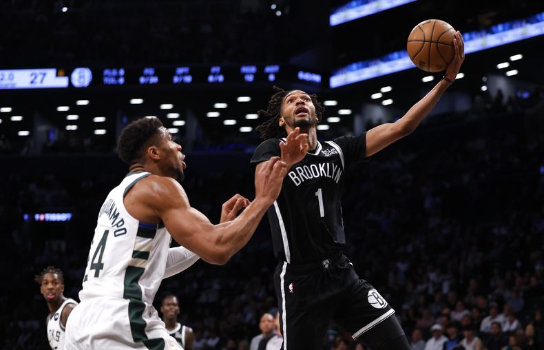 El alero de los Nets de Brooklyn Ziaire Williams avanza a la canasta con el balón frente al alero de los Bucks de Milwaukee Giannis Antetokounmpo en el encuentro del domingo 27 de octubre del 2024. (AP Foto/Noah K. Murray)