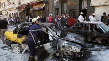 americateve | Los bomberos apagan un veh&iacute;culo incendiado despu&eacute;s que dos proyectiles de mortero hicieron impacto en la zona Abu Roumaneh de Damasco, Siria, el s&aacute;bado 12 de octubre de 2013. La agencia estatal de noticias siria inform&oacute; que los