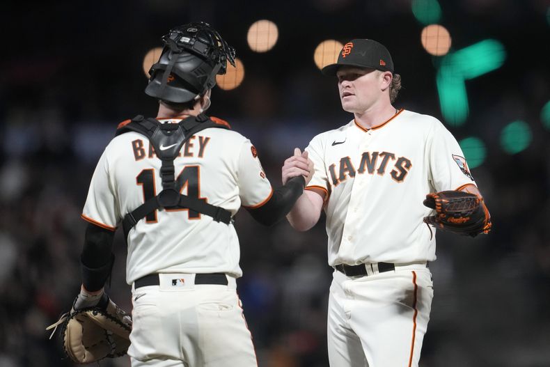 El cátcher de los Gigantes de San Francisco Patrick Bailey celebra con el pitcher Logan Webb la victoria de su equipo ante los Padres de San Diego el lunes 25 de septiembre del 2023. (AP Foto/Jeff Chiu)