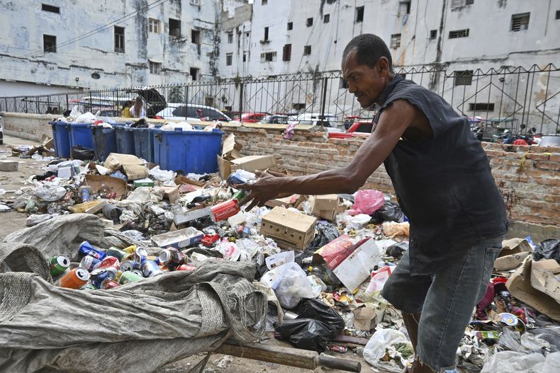 Un hombre hurga en la basura recolectando latas de aluminio para reciclar, en La Habana, Cuba, el martes 15 de julio de 2025. (Foto AP/Jorge Luis Baños)