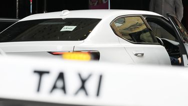 Un vehículo de Uber se detiene enfrente de una parada de taxi en Sydney, el lunes 18 de marzo de 2024. El servicio de transporte con conductor Uber pagará 272 millones de dólares australianos (178 dólares estadounidenses) para poner fin a una larga batalla legal con los conductores australianos de taxi y de alquiler que perdieron ventajas cuando la compañía entró en el mercado australiano. (AP Foto/Rick Rycroft)