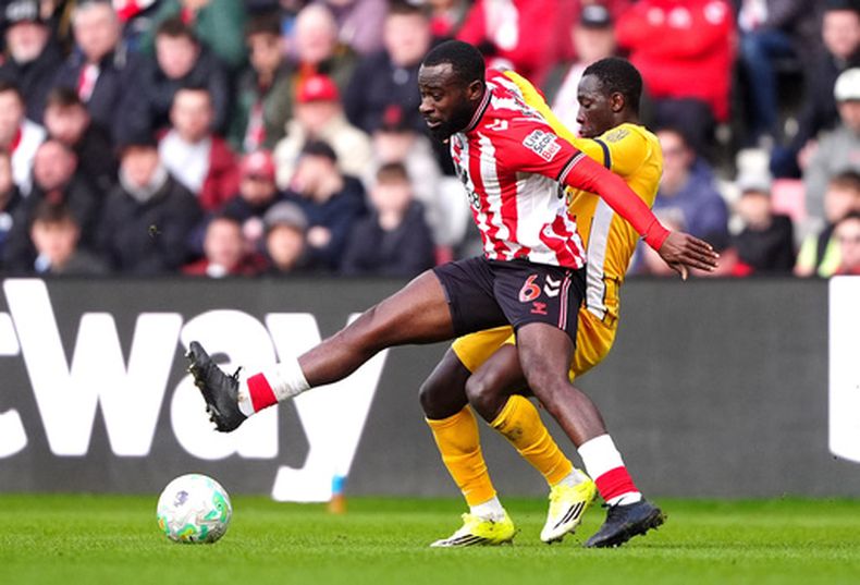 Lutsharel Geertruida (izquierda), del Sunderland, y el gambiano Yankuba Minteh, del Brighton and Hove Albion, luchan por el balón durante el juego de la Liga Premier en Sunderland, Inglaterra, el sábado 14 de marzo de 2026. (Owen Humphreys/PA vía AP)