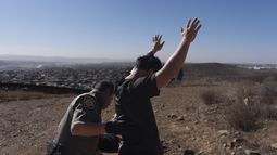Un agente de la Patrulla Fronteriza revisa a un hombre luego que un grupo de cuatro individuos cruzó la frontera de manera ilegal a través de un espacio entre dos muros que separan a México de Estados Unidos y se entregó a las autoridades estadounidenses, el jueves 23 de enero de 2025, en San Diego. (AP Foto/Gregory Bull)
