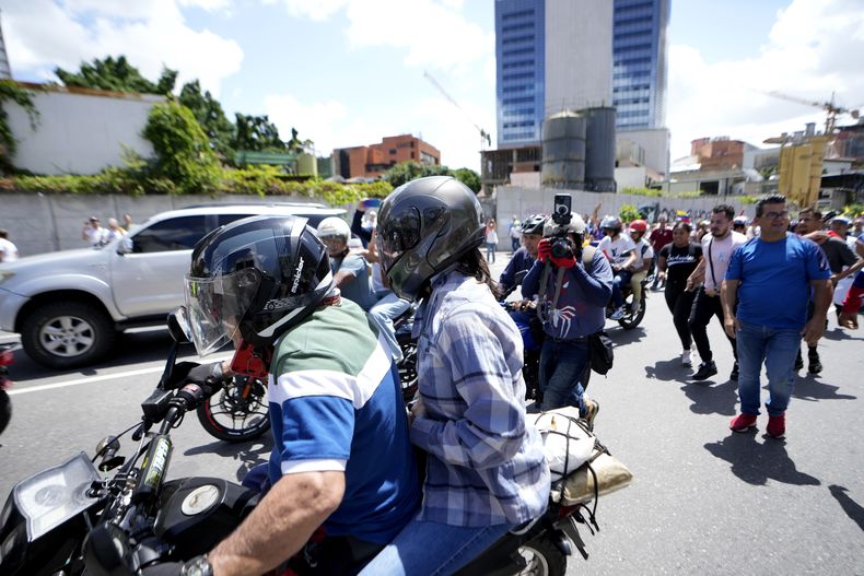 La líder opositora María Corina Machado es trasladada en motocicleta al final de una manifestación en Caracas, Venezuela, el sábado 3 de agosto de 2024. (Foto AP/Matías Delacroix)