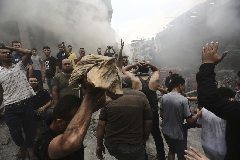 Palestinos reaccionan tras sacar el cuerpo sin vida de un niño de entre los escombros de un edificio luego de un ataque aéreo israelí sobre el campo de refugiados de Jebaliya, en la Franja de Gaza, el 9 de octubre de 2023. (AP Foto/Ramez Mahmoud )