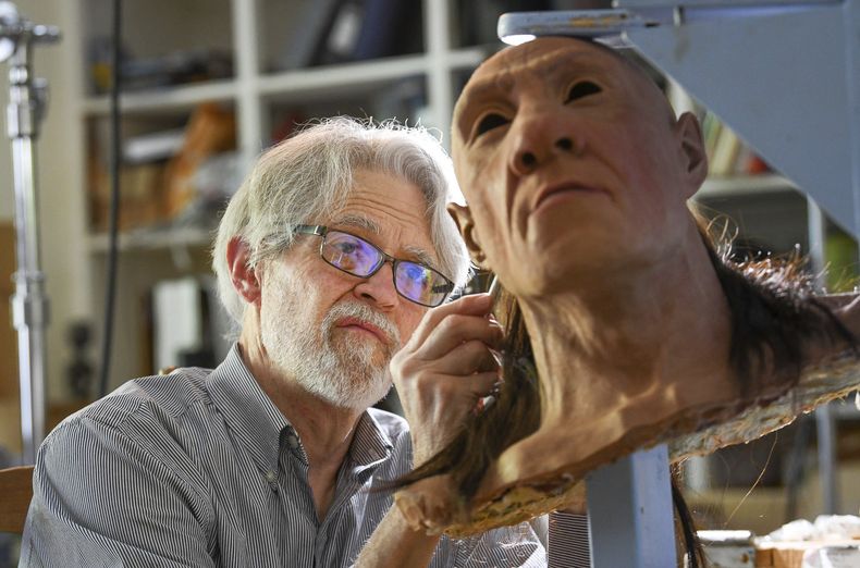 El paleoartista John Gurche le implanta pelo a Shanidar 1, un neandertal masculino, el miércoles 31 de mayo de 2023 en su estudio en Trumansburg, Nueva York. (AP Foto/Heather Ainsworth)