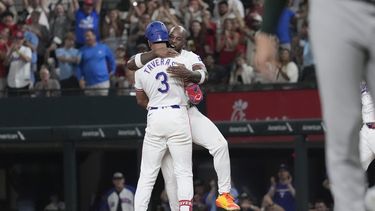El dominicano de los Rangers de Texas, Leody Taveras (3) es abrazado por su compañero de equipo, el cubano Adolis García luego de conectar un sencillo con bases llenas para remolcar a Ezequiel Durán en el noveno episodio y ganar el juego de béisbol ante los Atléticos de Oakland, el sábado 31 de agosto, de 2024, en Arlington, Texas. (AP Foto/LM Otero)