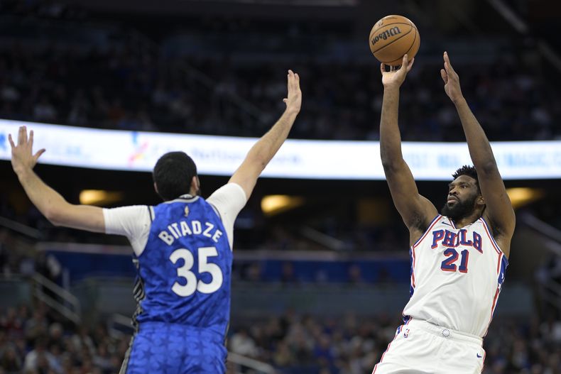 El centro de los 76ers de Filadelfia Joel Embiid (21) lanza frente al centro del Magic de Orlando Goga Bitadze (35) durante la primera mitad del juego de baloncesto de la NBA, el viernes 19 de enero de 2024, en Orlando, Florida. (AP Foto/Phelan M. Ebenhack)
