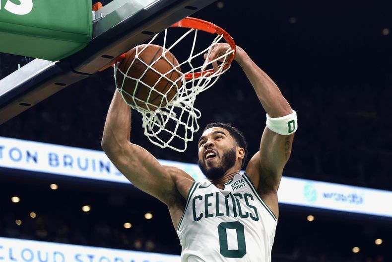 Jayson Tatum, de los Celtics de Boston, realiza una clavada en el encuentro ante el Heat de Miami, el viernes 27 de octubre de 2023 (AP Foto/Michael Dwyer)