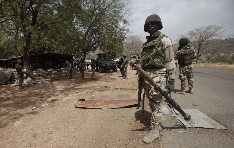 ARCHIVO - Soldados nigerianos controlan un puesto de control en Gwoza, Nigeria, el 8 de abril de 2015. (AP Foto/Lekan Oyekanmi, archivo)