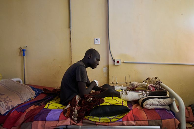 Emadeldein Babiker, de 17 años y que resultó herido por una explosión causada por una munición sin detonar, descansa en una cama en el hospital Al Nao en Omdurman, a las afueras de Jartum, Sudán, el 18 de abril de 2026. (AP Foto/Bernat Armangue)