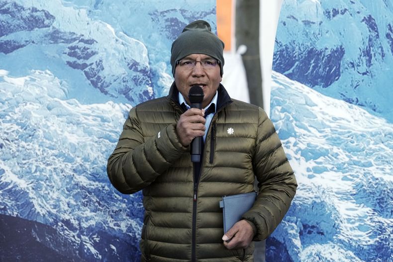 El agricultor peruano Luciano Lliuya habla a los medios ante imágenes de glaciares sostenidas por activistas en el Alto Tribunal de Hamm, Alemania, antes de la primera vista de su caso de daños climáticos contra la compañía energética alemana RWE por sus emisiones de dióxido de carbono, que podrían haber contribuido al deshielo de un glaciar cercano que podría inundar su casa, el lunes 17 de marzo de 2025. (AP Foto/Martin Meissner)