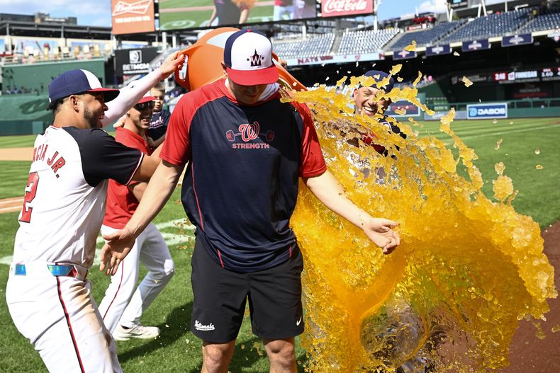 El abridor de los Nacionales de Washington Patrick Corbin es bañado por Luis García Jr. y el venezolano Ildemaro Vargas tras llevarse la victoria en el juego ante los Rockies de Colorado el jueves 22 de agosto del 2024. (AP Foto/Nick Wass)