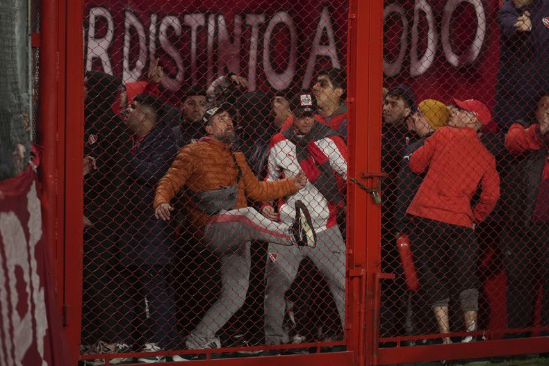 Hinchas de Independiente de Argentina tratan de abrir una reja por la fuerza durante un partido de la Copa Sudamericana ante Universidad de Chile, el miércoles 20 de agosto de 2025 en Avellaneda (AP Foto/Gustavo Garello)