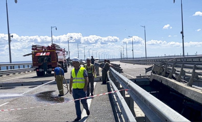 En esta imagen extraída de un video publicado el miércoles 19 de julio de 2023 por el Comité Nacional Antiterrorista Ruso, varias personas trabajan en las zonas dañadas del Puente de Kerch que conecta el territorio continental ruso con la península de Crimea, cerca de Kerch, Crimea. (Comité Nacional Antiterrorista Ruso via AP)