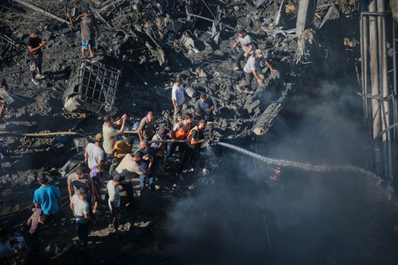 Palestinos intentan sofocar un incendio entre los escombros de un edificio destruido tras un ataque aéreo israelí en Ciudad de Gaza, el lunes 24 de agosto de 2026. (Foto AP/Jehad Alshrafi)