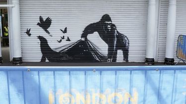 Una nueva obra de arte instalada por Banksy en el Zoológico de Londres, que representa a un gorila levantando una cortina metálica en la entrada permitiendo escapar a varias aves, mientras se pueden ver los ojos de otros animales acechando en la oscuridad, la novena obra de arte de su colección de temática animal en Londres, el martes 13 de agosto de 2024. (Stefan Rousseau/PA via AP)