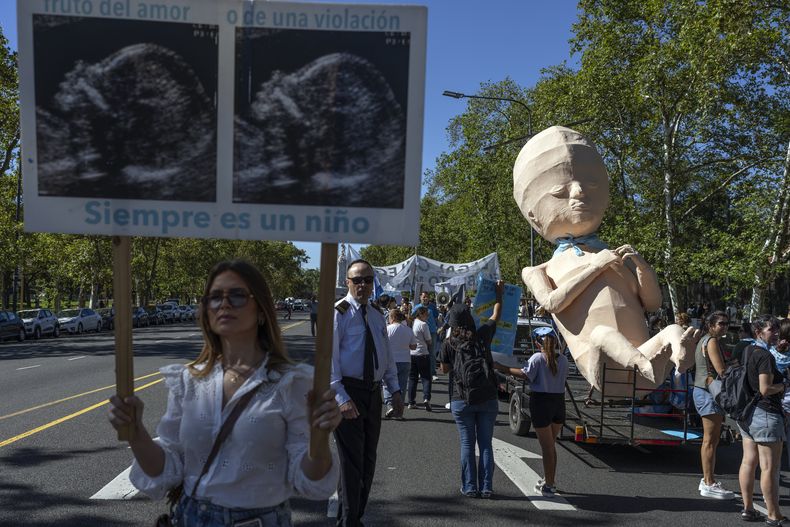 Manifestantes en defensa de la vida humana desde la concepción junto a una carroza que representa a un feto transportado en la plataforma de un remolque, durante una marcha contra la política progresista argentina sobre el derecho al aborto, en Buenos Aires, el sábado 29 de marzo de 2025. (Foto AP/Rodrigo Abd)