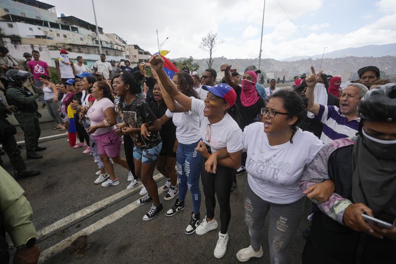 La gente bloquea una calle para protestar por los resultados oficiales el día después de las elecciones presidenciales en Caracas, Venezuela, el lunes 29 de julio de 2024. (AP Foto/Fernando Vergara)