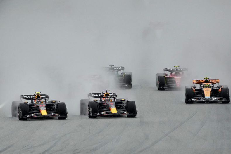 Max Verstappen (centro) y su compañero de Red Bull Sergio Pérez compiten en el sprint del Gran Premio de Austria, el sábado 1 de julio de 2023, en Spielberg, Austria. (AP Foto/Darko Vojinovic)