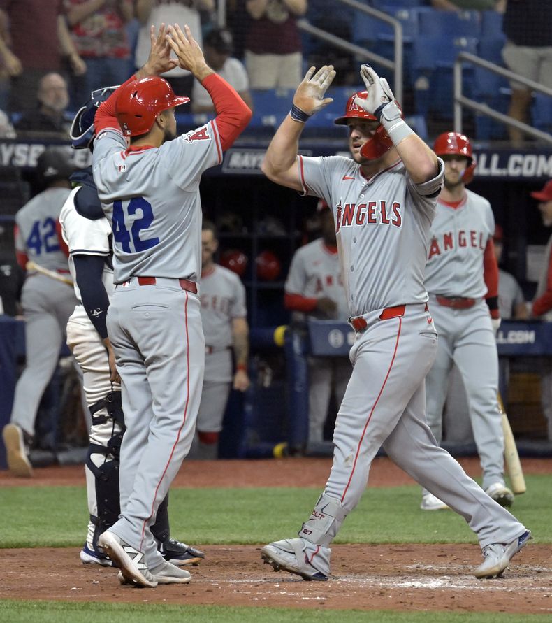 Mike Trout, derecha, de los Angelinos de Los Ángeles, celebra con Anthony Rendón después de batear cuadrangular de dos carreras contra el relevista de los Rays de Tampa Bay, Phil Maton, durante la octava entrada del juego de béisbol del lunes 15 de abril de 2024, en San Petersburgo, Florida. (AP Foto/Steve Nesius)