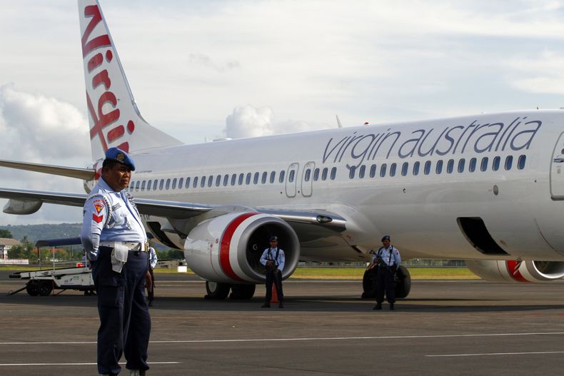 Elementos de la Fuerza A&eacute;rea de Indonesia resguardan el avi&oacute;n de Virgin Australia que emiti&oacute; una alerta de secuestro y ateriz&oacute; en Bali, Indonesia, el viernes 25 de abril de 2014. Un pasajero australiano en estado de ebriedad tr