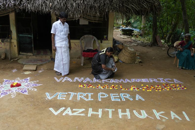 La política Arulmozhi Sudhakar prepara un kolam, una forma de arte tradicional que utiliza polvo de colores, con la frase Saludos a America, nuestros deseos de victoria para Kamala Harris, para la candidata demócrata a la Casa Blanca, Kamala Harris, en Thulasendrapuram, el pueblo ancestral de Harris, en el estado de Tamil Nadu, India, el 5 de noviembre de 2024. (AP Foto/Aijaz Rahi)